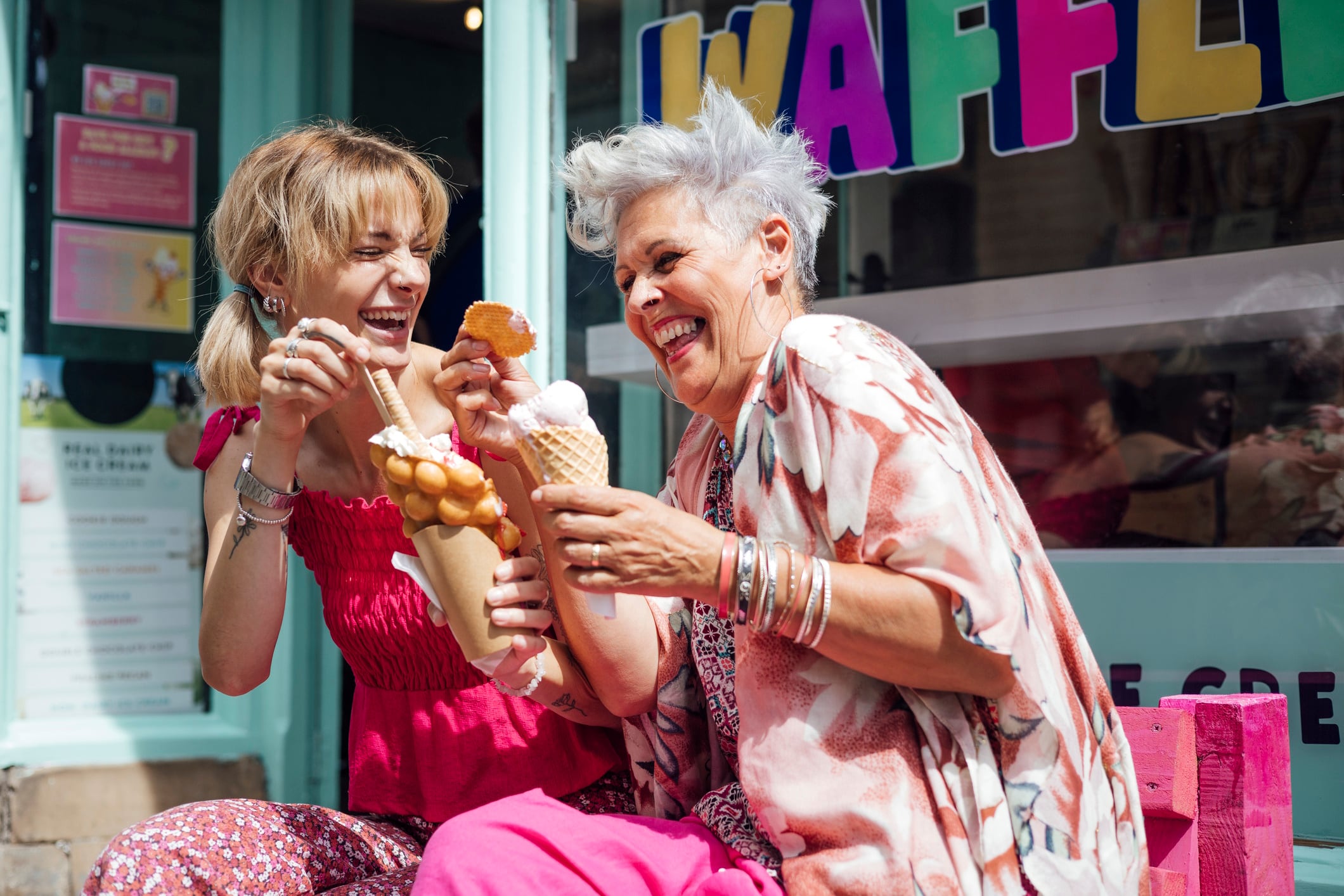 Summer snacking: Two women enjoy ice cream and bubble waffles